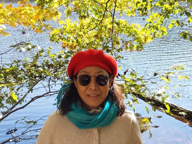 Marti Hand surrounded in nature at Stone Mountain, Cherokee Trail, with lake and trees in the background