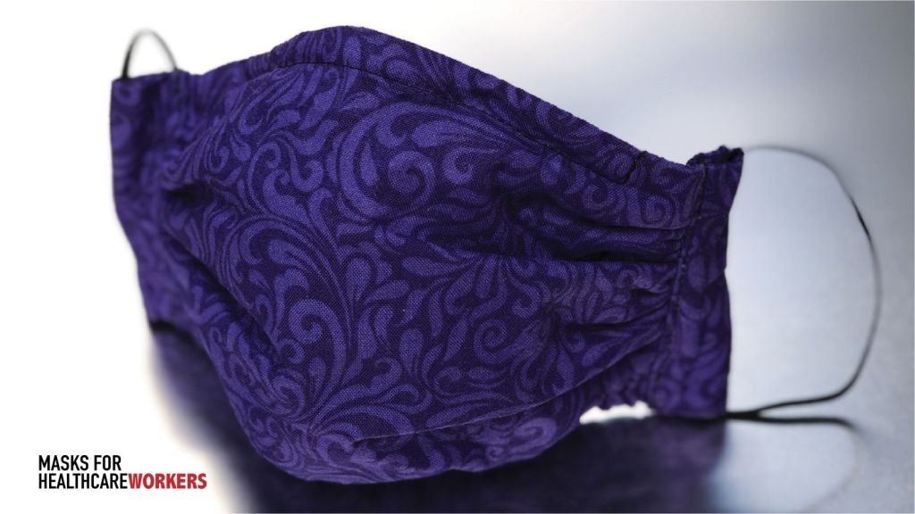 photo of purple and deep purple floral design fabric 100% cotton face mask with 2 ear strings with light grey bakcground