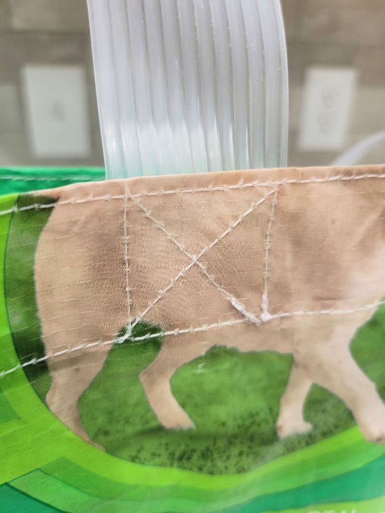 close-up image of stitching of upcycled dog food bags into useable shopping bags with study stitching