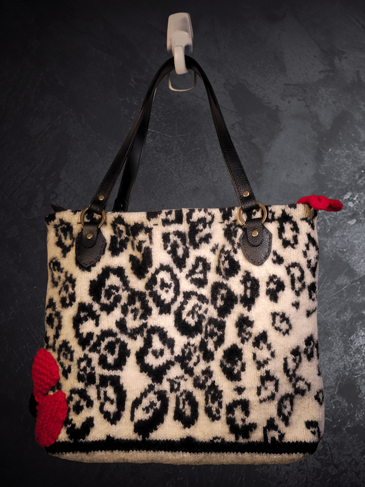photo of upcycled bag with double black faux leather straps knitted red flower on the left side with multicolor black background
