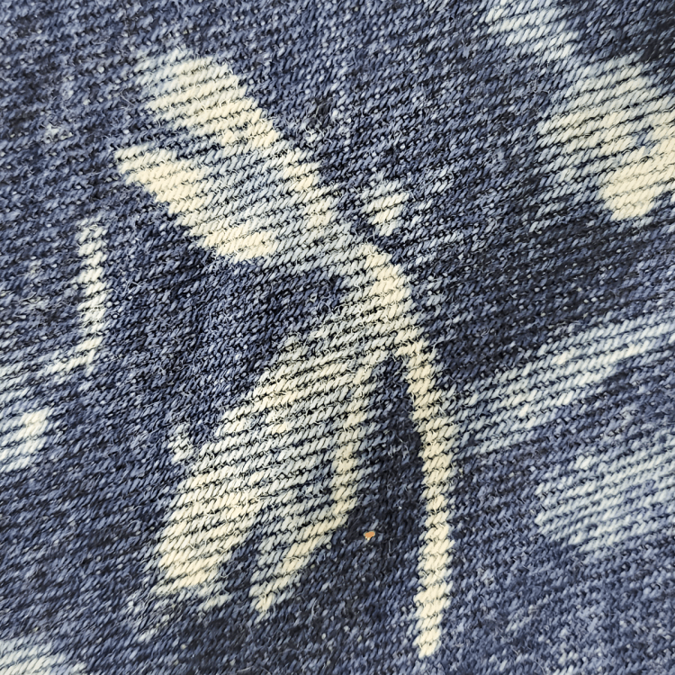 closeup photo of upcycled denim with dragonfly painted with bleach