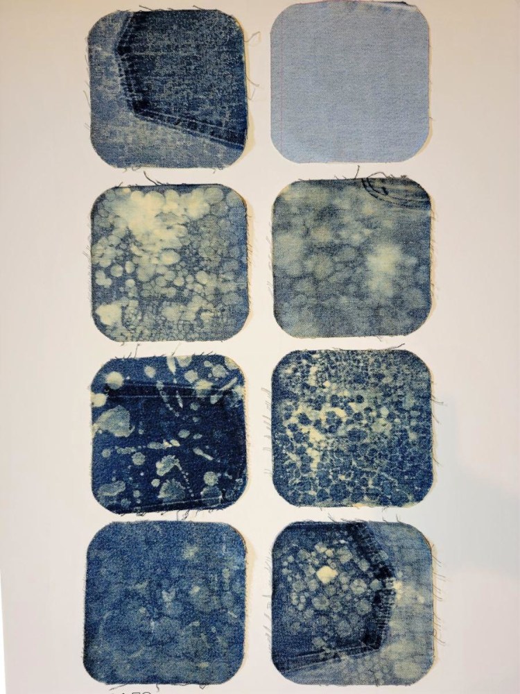 photo of 8 denim squares with bleach painting designs on white background