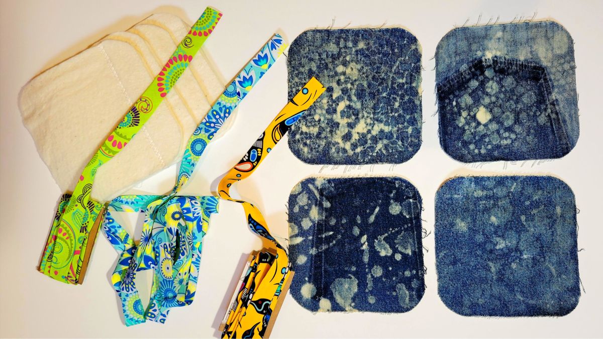 photo of 4 denim squares with bleach painting, strips of colorful bias tape and 100% cotton batting